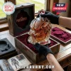Predator helmet shaped glass whiskey decanter filled with amber liquid, displayed in a wooden box with red velvet lining.!
