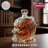 Predator helmet glass decanter filled with amber liquid, sitting on a wooden desk with a library background.!