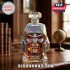 Megatron-shaped glass whiskey decanter with 20th anniversary 2007-2027 engraving filled with amber liquid on a wood desk.!