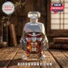 Megatron-shaped glass whiskey decanter filled with amber liquid, featuring a 20th anniversary label on a wooden desk.!