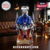 Optimus Prime shaped glass whiskey decanter with blue and silver plating, 20th anniversary text, on a wooden bar table.!