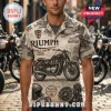 Man wearing a cream-colored short-sleeve shirt with black Triumph motorcycle graphics, British flag motifs, and text.!