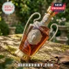 Champions League trophy whiskey decanter with gold metal handle and base on a mossy wooden surface.!
