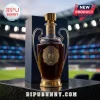 Glass whiskey decanter shaped like a European soccer trophy with gold metal base, rim, and central emblem on stadium background.!