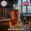 The Wolf Man shaped glass decanter filled with amber liquid, featuring a brass plaque on a dark wooden library desk.!