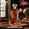 The Wolf Man shaped glass whiskey decanter with a crystal stopper, amber liquid, and yellow text on a wooden desk.!