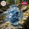 Blue crystal decanter shaped like a UNC ram head with a sailor hat stopper, resting on a rocky stream ledge.!