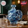 Blue glass decanter shaped like a ram head with UNC lettering on a sailor hat cap, sitting on a wooden table with whiskey.!