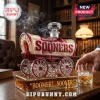 Glass whiskey decanter shaped like a covered wagon with red and white accents, inscribed with SOONERS and BOOMER SOONER.!