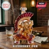 Amber crystal Roman centurion helmet whiskey decanter with a red crest and Fight On! 1888-2026 plaque on a wooden table.!