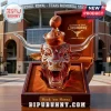 Amber glass longhorn head decanter with a football stopper, resting in a velvet-lined box against a stadium background.!