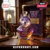 Faceted purple glass decanter shaped like a husky head with University of Washington logo, resting on a leather desk.!