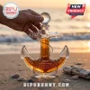 Anchor-shaped glass whiskey decanter with US Navy 250th anniversary etching and crystal stopper on a sandy beach at sunset.!