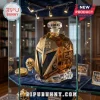 Golden faceted helmet-shaped whiskey decanter labeled The Golden Misfits 2017-2027 displayed in a lighted glass cabinet.!