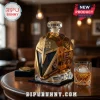 Gold faceted helmet whiskey decanter labeled The Golden Misfits 2017-2027 with glass and ice on a wooden table.!