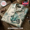 Folded Vespa Milano cream shirt with teal scooter graphics, Italian landmarks, and vintage postage stamp patterns.!