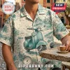 Short-sleeve button-down shirt with a teal Vespa pattern, Italian coastal landmarks, and text on a light beige fabric.!