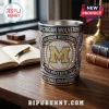 Michigan Wolverines NCAA basketball championship metal tumbler with blue and gold accents on a wooden office desk.!