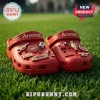 Arsenal FC 140th Anniversary Crocs With Charms in red featuring club logos, stadium, and football-themed pins on grass.