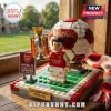 Arsenal FC minifigure holding a trophy on a LEGO pitch display with a red and white soccer ball, placed on a windowsill.!