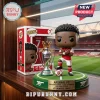 Bukayo Saka vinyl figure in Arsenal kit with Premier League trophy on a grass-textured base inside product packaging.!