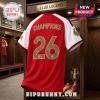 Red and white Arsenal-style football jersey with Champions 26 on the back hanging in a wooden locker room display.!