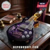 Black Sabbath themed electric guitar with a glass whiskey bottle neck on a dark leather desk.!