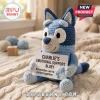 Blue and light blue crochet dog doll holding a card reading Charlie's Emotional Support Bluey on a white knit blanket.!