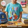 Child wearing cyan Bluey t-shirt next to matching Bluey backpack, pencil case, and school supplies on a wooden desk.!