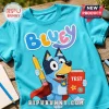 Bright blue Bluey t-shirt featuring Bluey holding a yellow pencil and a red notebook labeled TEST with a red cape.!