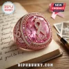 Rose gold ring with a large pink gemstone, a pavé ribbon, and engraved text reading Breast Cancer Awareness and Hope.!