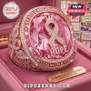 Rose gold breast cancer awareness ring with a large pink gemstone, central ribbon emblem, and text reading HOPE and STRENGTH.!