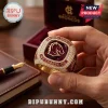 Brisbane Broncos We Charge On gold championship ring with a maroon center stone and team logo held by a person.