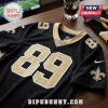 New Orleans Saints black and gold jersey number 89 with NFL shield logo on a wooden table near a glass of whiskey.!