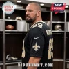 Man wearing a black New Orleans Saints jersey with number 89 in a locker room setting with athletic gear.!