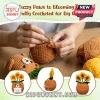 Hands crocheting a brown yarn bear planter with three yellow sunflowers attached to its head on a wooden table surface.!