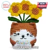 Crocheted brown and white cat holding a card with three yellow sunflowers on top against a white background.!
