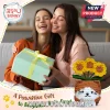 Crocheted brown cat planter with yellow sunflowers and a small card held by two women embracing on a sofa.!