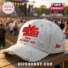 BTS Distressed Baseball Cap in light grey denim with red embroidered member names and world tour logo on wooden railing.