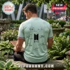 Man wearing a light green BTS t-shirt featuring band member signatures and the black BTS logo on the back.!