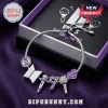 BTS Purple I Purple You Charm Bracelet with silver snake chain, microphone, heart, and logo charms on purple fabric.
