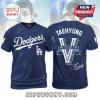 BTS Taehyung Los Angeles Dodgers T-shirt featuring navy blue fabric, white Dodgers script, and V lettering on the back.