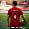 Man wearing red FC Bayern jersey with BTS logo and white signatures standing in a stadium holding a leather soccer ball.!