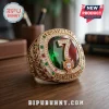 Gold Cristiano Ronaldo championship ring with Portugal crest, number 7, green and red gemstones, on a wooden desk.!