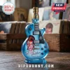Blue glass guitar-shaped Bombay Sapphire gin bottle featuring David Bowie Aladdin Sane portrait on a wooden surface.!