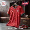 Red Portugal national soccer jersey with thin wavy lines, green collar trim, Puma logo, and crest on a wooden hanger.!