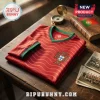 Folded red Portugal national soccer jersey with green trim and crest on a dark wooden table with vintage photos.!