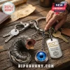 Dune sandworm keychain with a blue spice eye charm and 60th anniversary metal dog tag on a wood desk.!