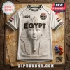 White jersey featuring a stone Pharaoh mask graphic, Egypt text, 2026 year, and Egyptian flags on a marble-textured surface.!