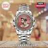 Elvis Presley commemorative wristwatch with gold and silver link band, pink dial, crown motif, and crystal-studded bezel.!